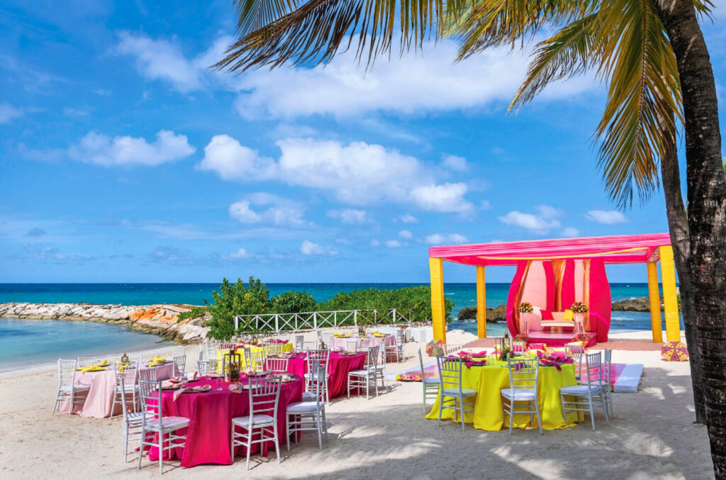 Resort beach with yellow and pink decoration and set up for a wedding party